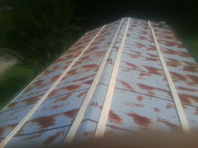 Rusted metal roof panels with new wood purlins before replacement — Storm Damage Roof Repair in Land O Lakes by Roofing Brothers