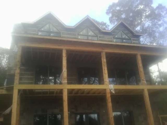 Dormers and porch framing on a large log home under construction — Roof Coating work by our crew in Land O Lakes