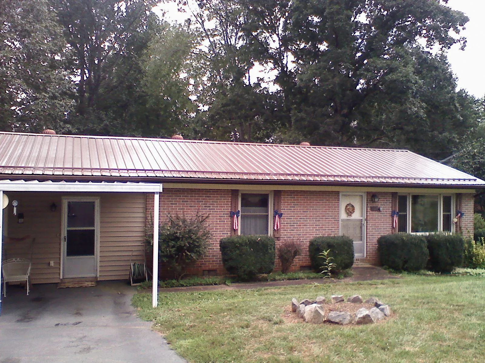Bronze metal roof and carport on a brick ranch home — Roof Repair work by our crew in Land O Lakes